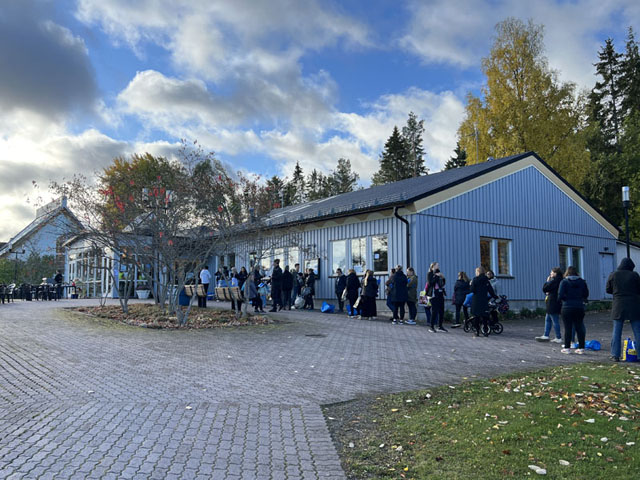 Shoppingsugna besökare utanför församlingsgården väntar på att Storvreta barnloppis ska öppna.